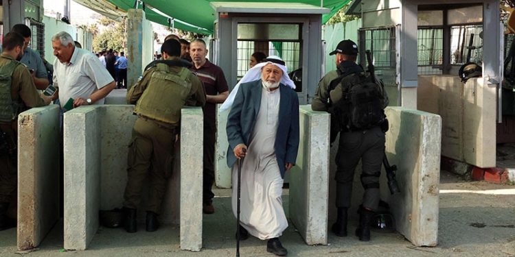 Israeli security forces keep watch as Palestinians cross a checkpoint to reach the city of Jerusalem to attend the last Friday prayers of Ramazan in the al-Aqsa mosque compound, April 29 in Bethlehem in the occupied West Bank. — AFP