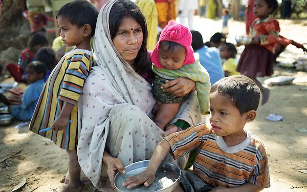 Anita Devi sits with her three children (LtoR) Sandeep, Sanjit and Deepak (eating the school-provided midday meal). Like many of the men from Jalhe Bogiya village, Anita's husband Sukhdev Mandal works at a brick kiln for 4-5 months a year. Lack of irrigation and food security lie at the root of the Maha Dalit community's problems in the village of Jalhe Bogiya. In the exploitative and divisive caste system, Maha Dalits are considered the lowest of the low. Ostracized by wider society (including the administration) illiteracy runs as high as 95 percent. Thanks to Oxfam-supported intervention, Jalhe Bogiya now has an - as yet incomplete - access-road built as part of the NREGA (National Rural Employment Guarantee Scheme). And an Oxfam-supported initiative in summer 2010 successfully lobbied the local administration to implement the provision of school midday meals which, by law is the right of every child. It is alleged that the Anganwadi (pre-school) centre administrator, syphons off food meant for young children. Jalhe Bogiya has several hand pumps supplying water but these do not work between the months of May to October. And though the village was connected to the electricity grid six months ago, power-supply is not reliable. Without land-ownership and only irregular agricultural work from which to earn an income, the Maha Dalits of Jalhe Bogiya frequently migrate in search of labour at stone breaking quarries, brick-kilns or undertake menial household work in the homes of the urban middle class in far-away cities. Photo: Tom Pietrasik Mohanpur Block, Gaya District, Bihar. India February 23rd 2011