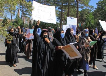 Afghan women hold placards and don burkas as they take part in a protest in Herat on September 2, 2021. (AFP)