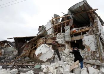 Local residents remove debris from a house of their neighbour damaged by a Russian military strike, amid Russia's attack on Ukraine, in the town of Hlevakha, outside Kyiv, Ukraine [Valentyn Ogirenko/Reuters]