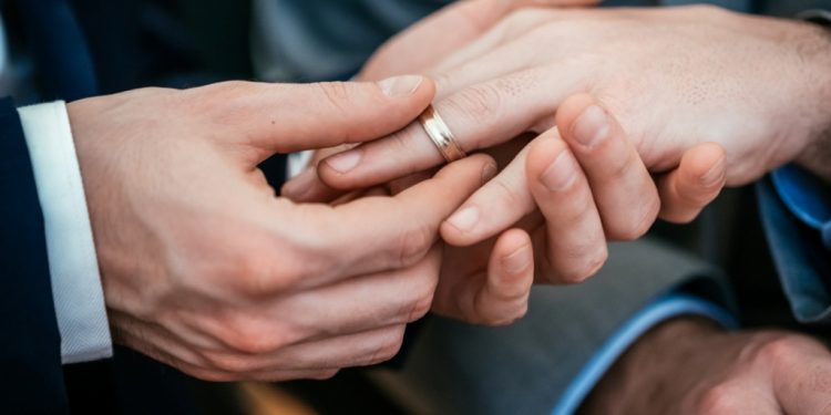 Gay Wedding Groom Placing Ring On Husband