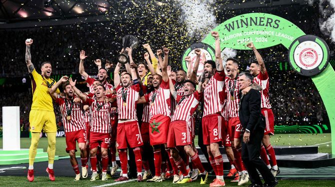 Olympiakos Greek midfielder Konstantinos Fortounis (C) and Olympiakos players celebrate with the trophy after winning the UEFA Europa Conference League final against Fiorentina at the AEK Arena in Athens on May 29, 2024. (AFP)