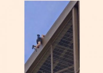 A man is seen climbing the Eiffel Tower, prompting an evacuation hours before closing ceremony