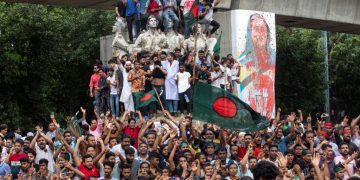 Protesters climb a public monument as they celebrate after getting the news of Prime Minister Sheikh Hasina’s resignation, in Dhaka, Bangladesh, August 5, 2024 (AP/PTI)